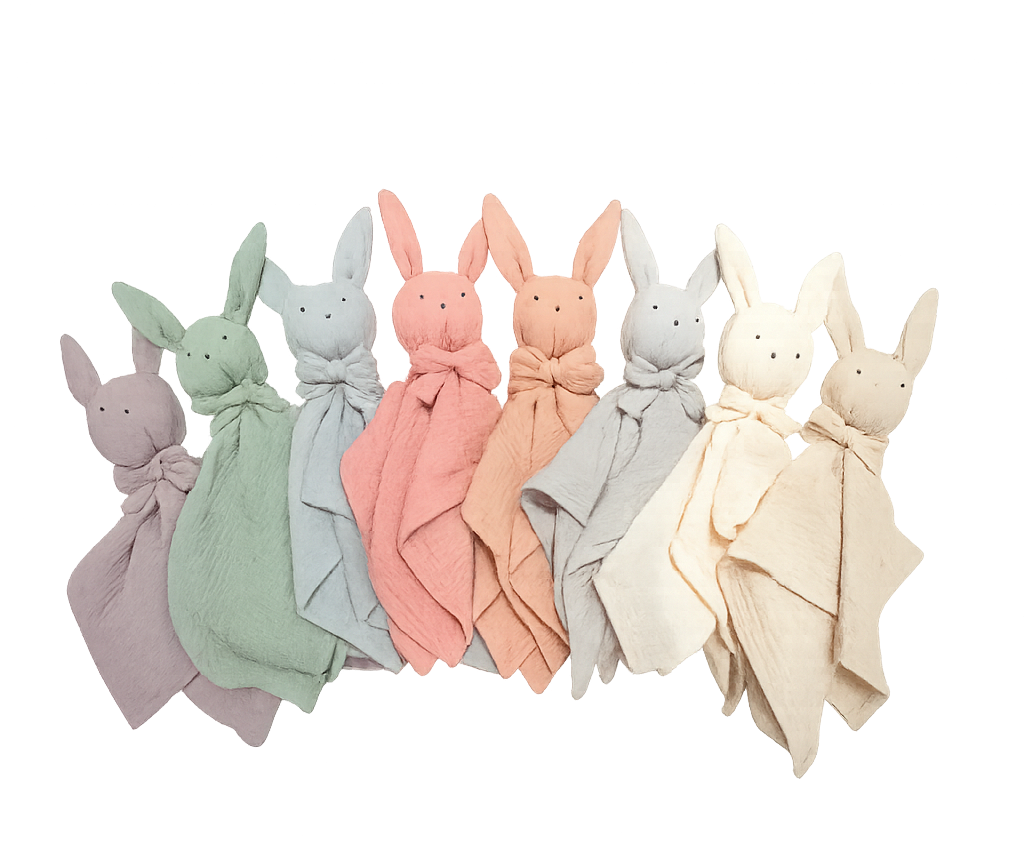 Pastel-colored baby bunny comforters with stitched eyes and long ears, arranged in a row on transparent background soft textured fabric ideal for newborn comfort and sleep.